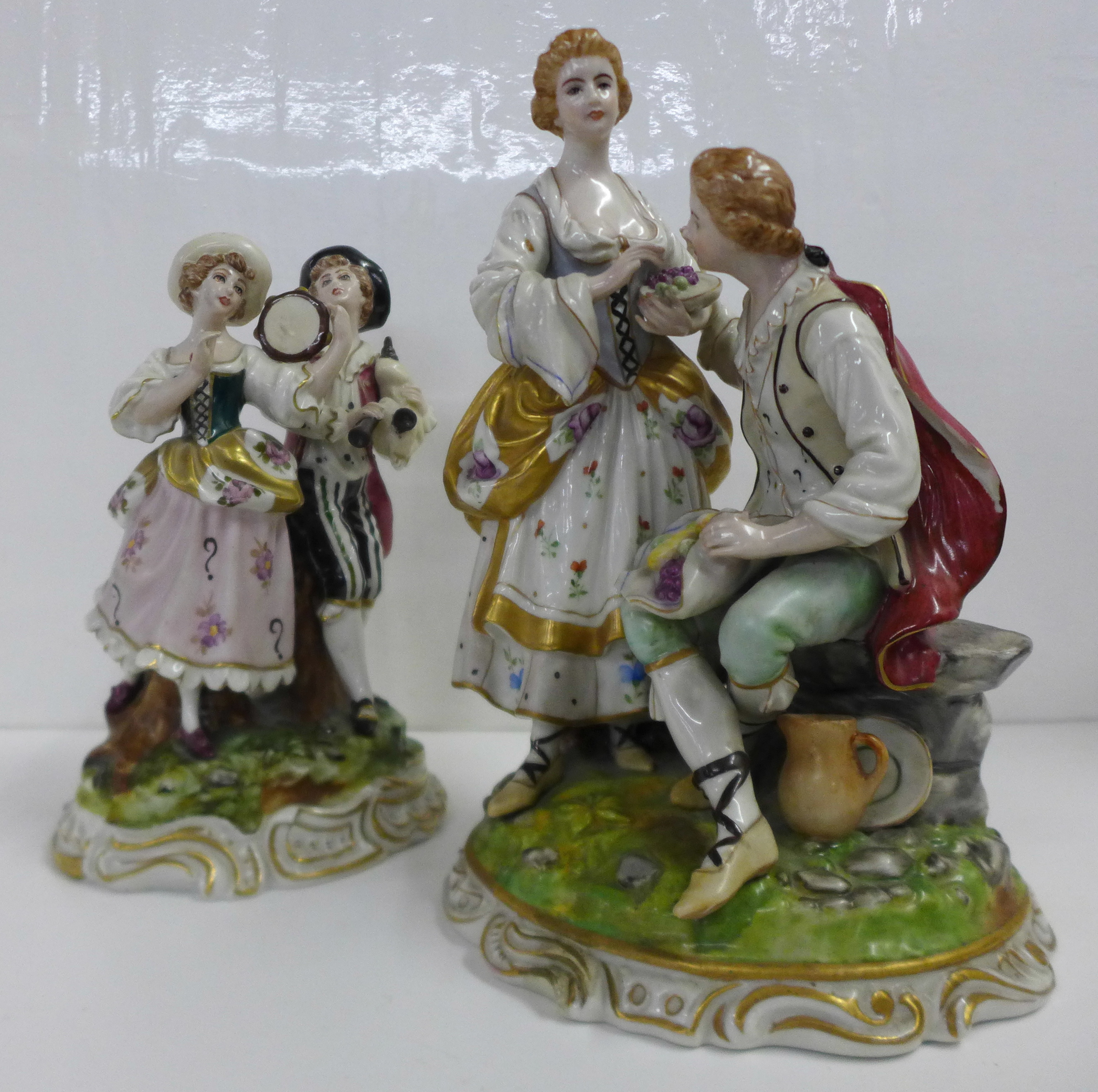 Two German porcelain figure groups; musicians and a courting couple with fruit, some a/f