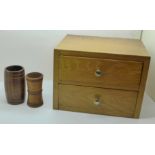 A wooden miniature chest of drawers and two wooden dice shakers