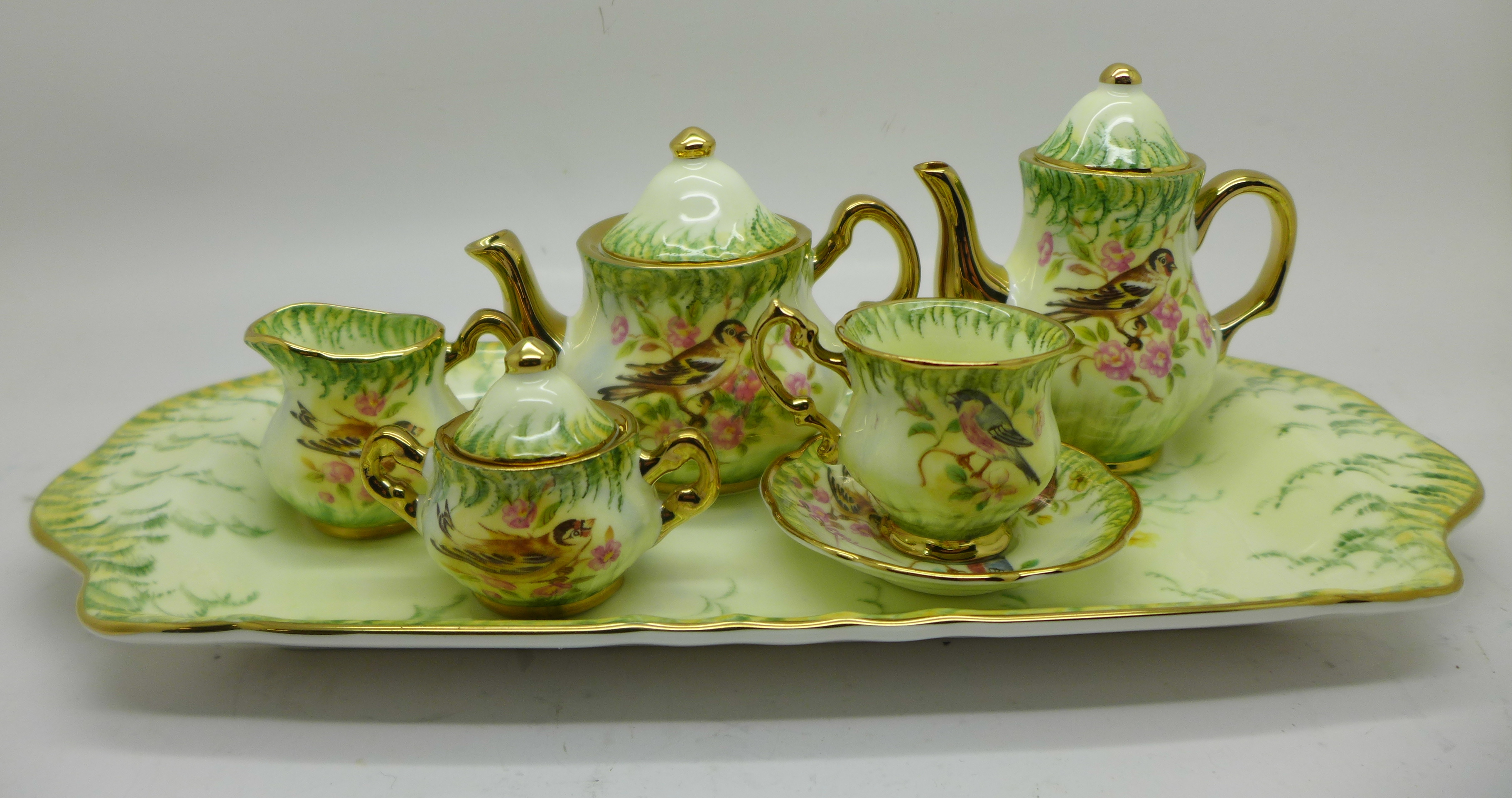 A Lymes China miniature tea service with tray, decorated in the Victorian Birds design