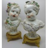 A pair of late 19th Century Meissen porcelain busts of young children on gilt bronze bases, 25cm