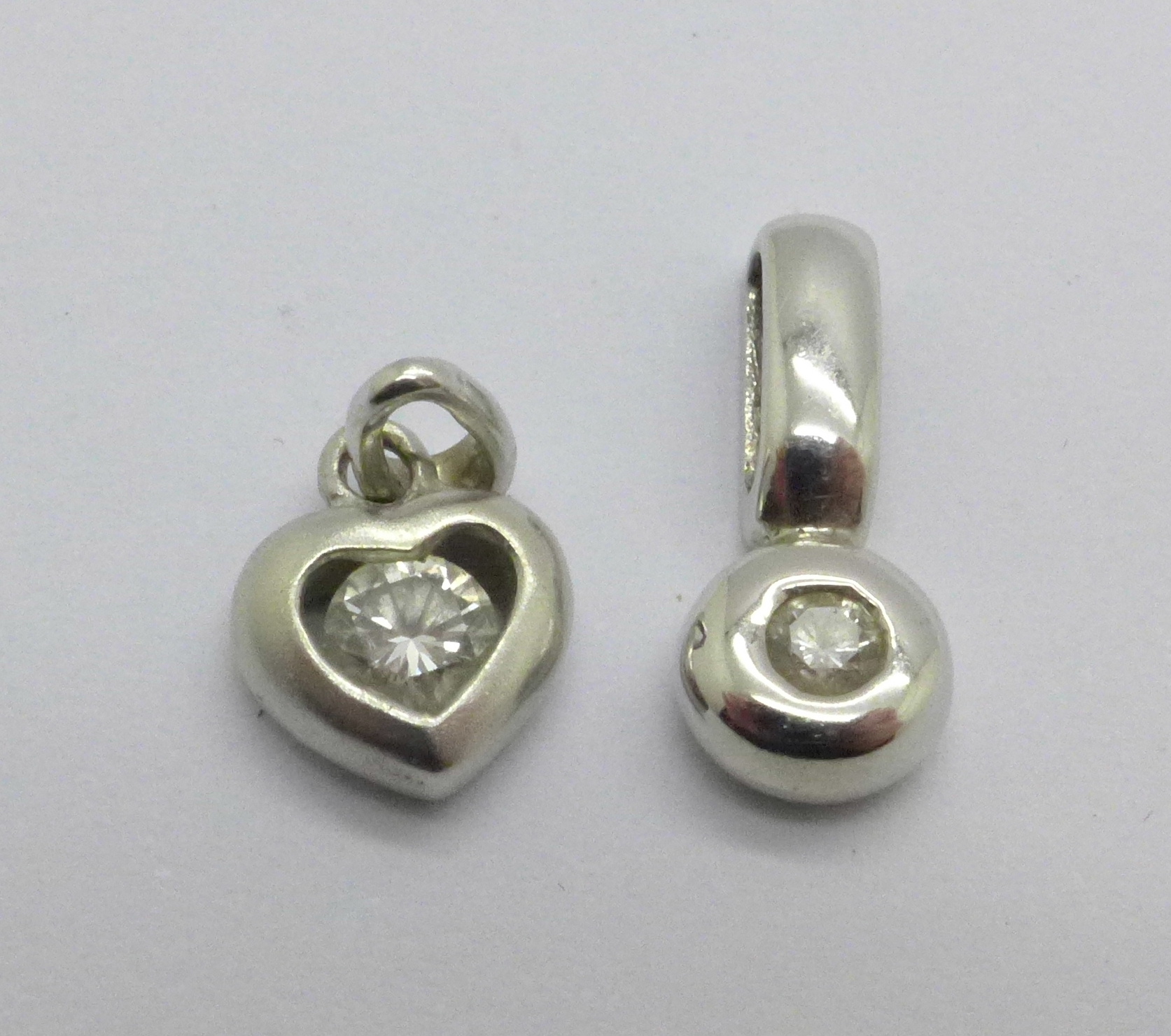 An 18ct gold and diamond heart shaped pendant, (1g), and a 9ct gold and diamond pendant, (0.9g)