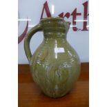 A large celadon glazed terracotta jug