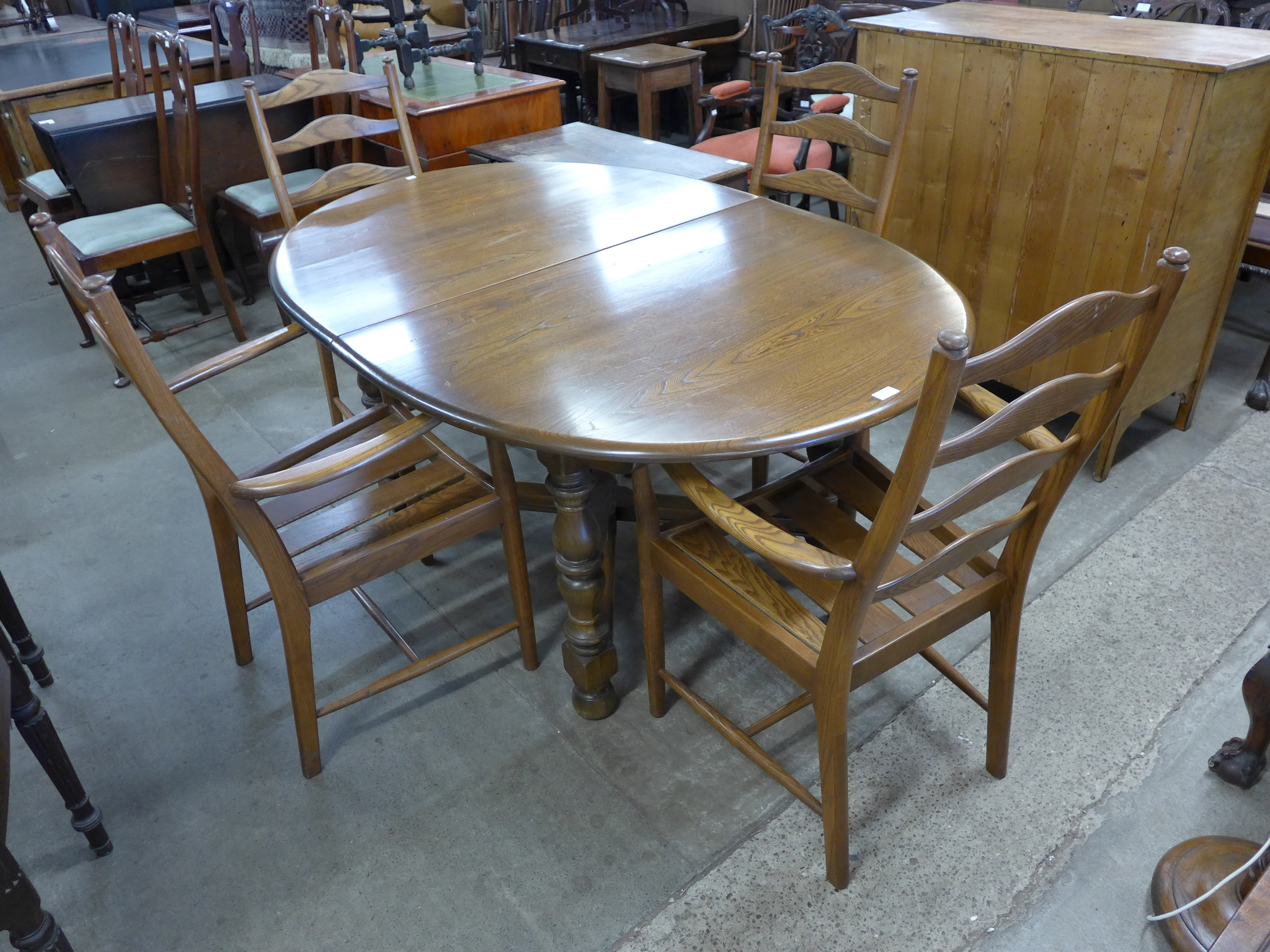 An Ercol Golden Dawn elm and beech extending dining table and four chairs