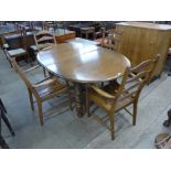 An Ercol Golden Dawn elm and beech extending dining table and four chairs