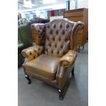 A mahogany and tan buttoned leather wingback armchair