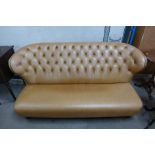 A tan leather buttoned settee