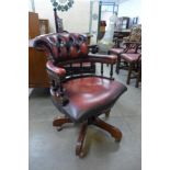 A mahogany and red leather captain's revolving desk chair