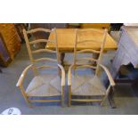 A pair of Arts and Crafts beech and rush seated ladderback armchairs