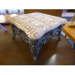 An Art Nouveau style cast iron and upholstered footstool