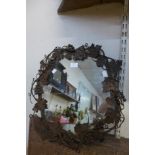 A wrought alloy grape vine framed mirror