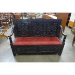 A 17th Century style carved ebonised settle