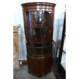 A George III style mahogany bow-front freestanding corner cabinet