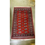 A Pakistani hand knotted Bokhara red ground rug, 158 x 96cms