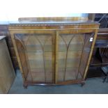 A walnut two door bow front display cabinet