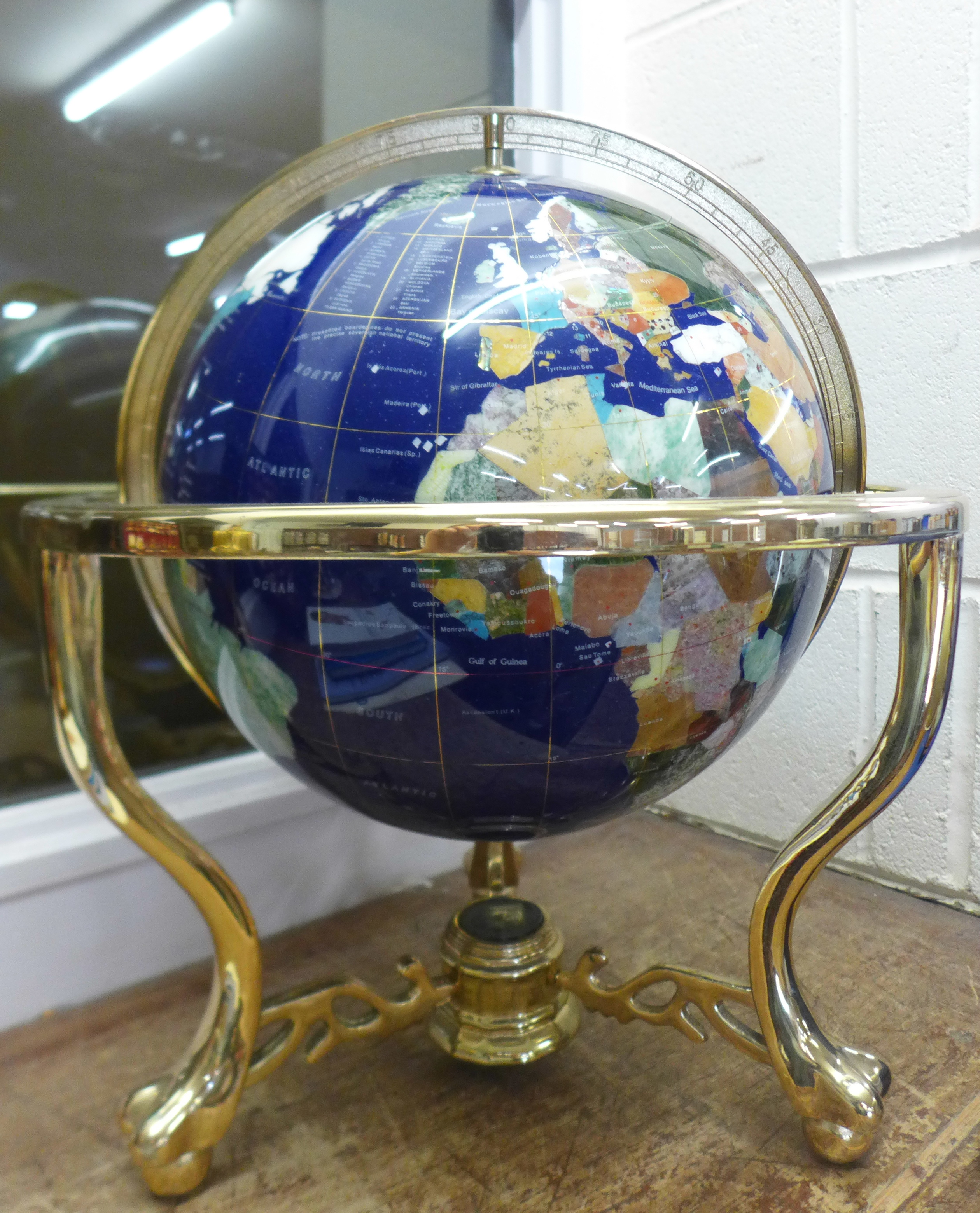 A gem set globe on a brass stand