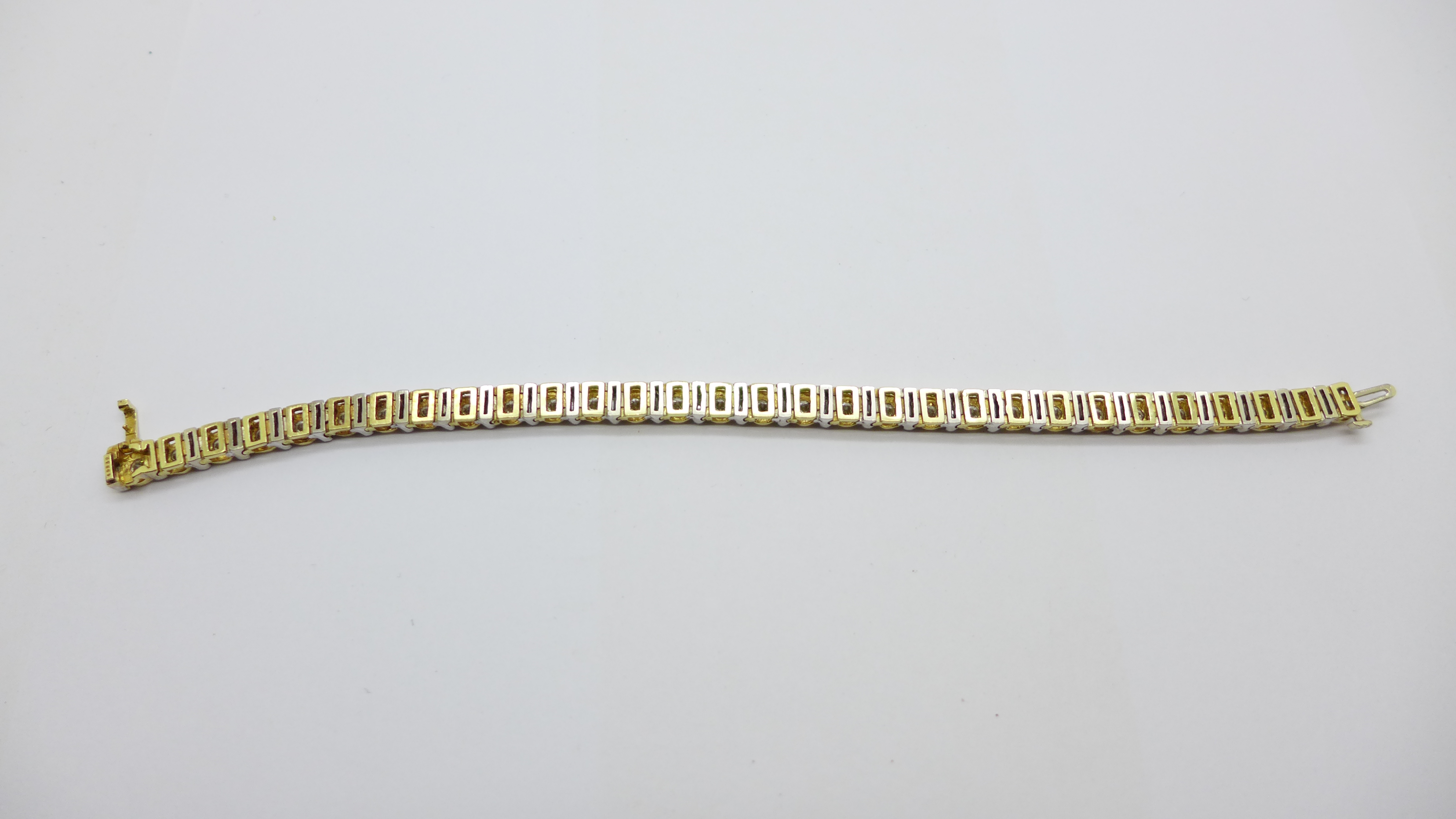 A 14k gold and diamond tennis bracelet with sixty diamonds, approximately 7ct diamond weight, 21.4g - Image 5 of 6