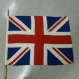 A Union Jack on parade pole with brass finial and a Girl Guides flag on parade pole with cast