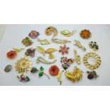 A collection of twenty-four gold tone and floral style brooches