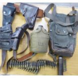 A box of militaria including holsters, ammo belt, water canteen, etc.