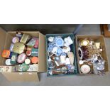 Three boxes of items including a collection of tins, a ceramic lamp base, mugs, china, Wedgwood