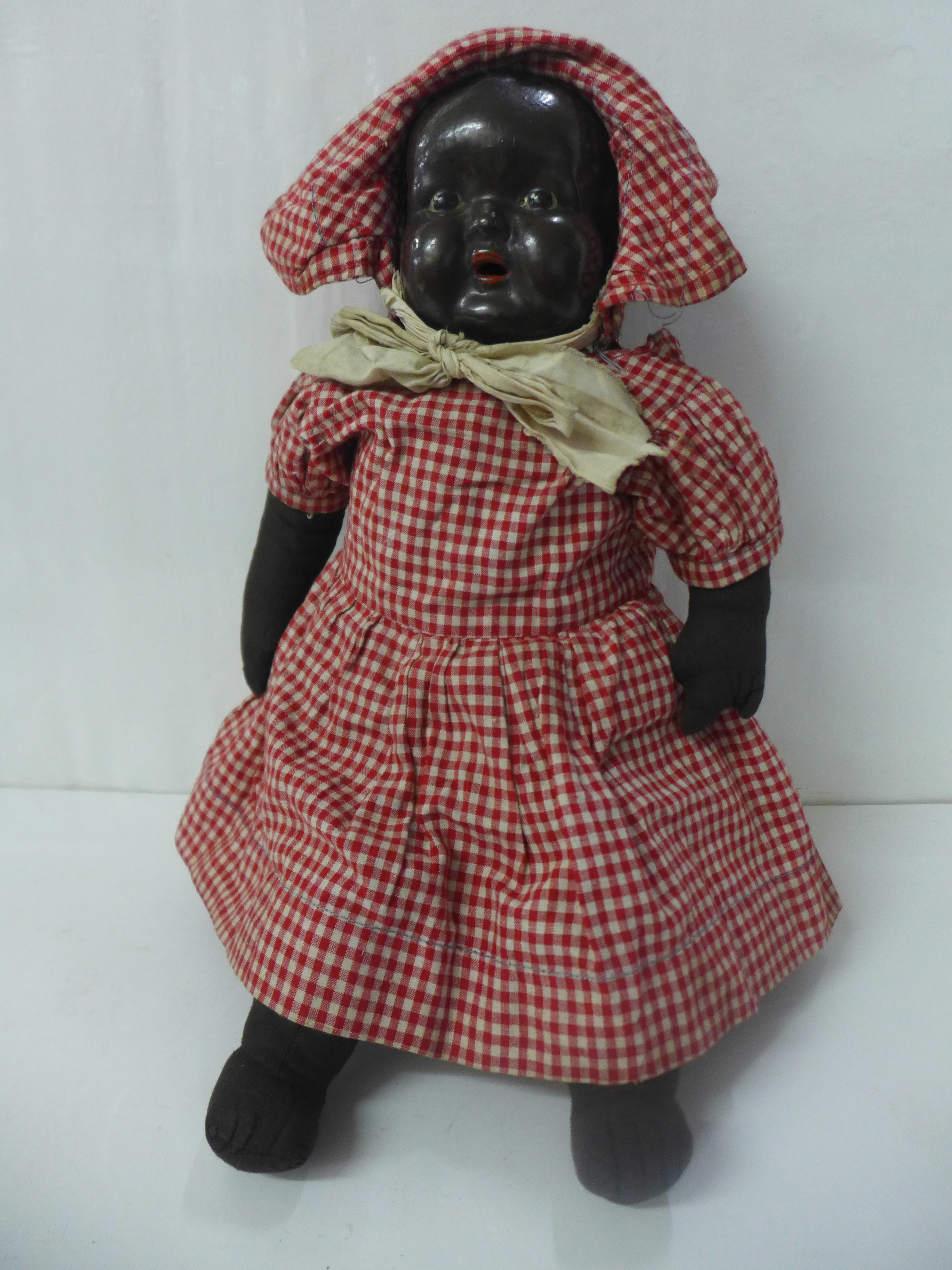 A black soft bodied doll with composition head