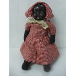 A black soft bodied doll with composition head