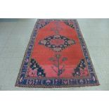 A Persian red ground rug, 230 x 144cms