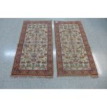 A pair of cream ground rugs, 132 x 69cms