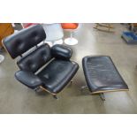 A Charles & Ray Eames style rosewood effect and black leather revolving lounge chair and footstool