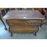 A Dutch oak three drawer bombe shaped petit commode