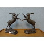 A pair of bronze boxing hares, on black marble socles