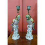 A pair of French style porcelain parrot candlestick holders