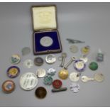 A collection of badges, including enamel and a commemorative token