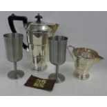 An Art Deco teapot, jug, two goblets and pocket dominoes