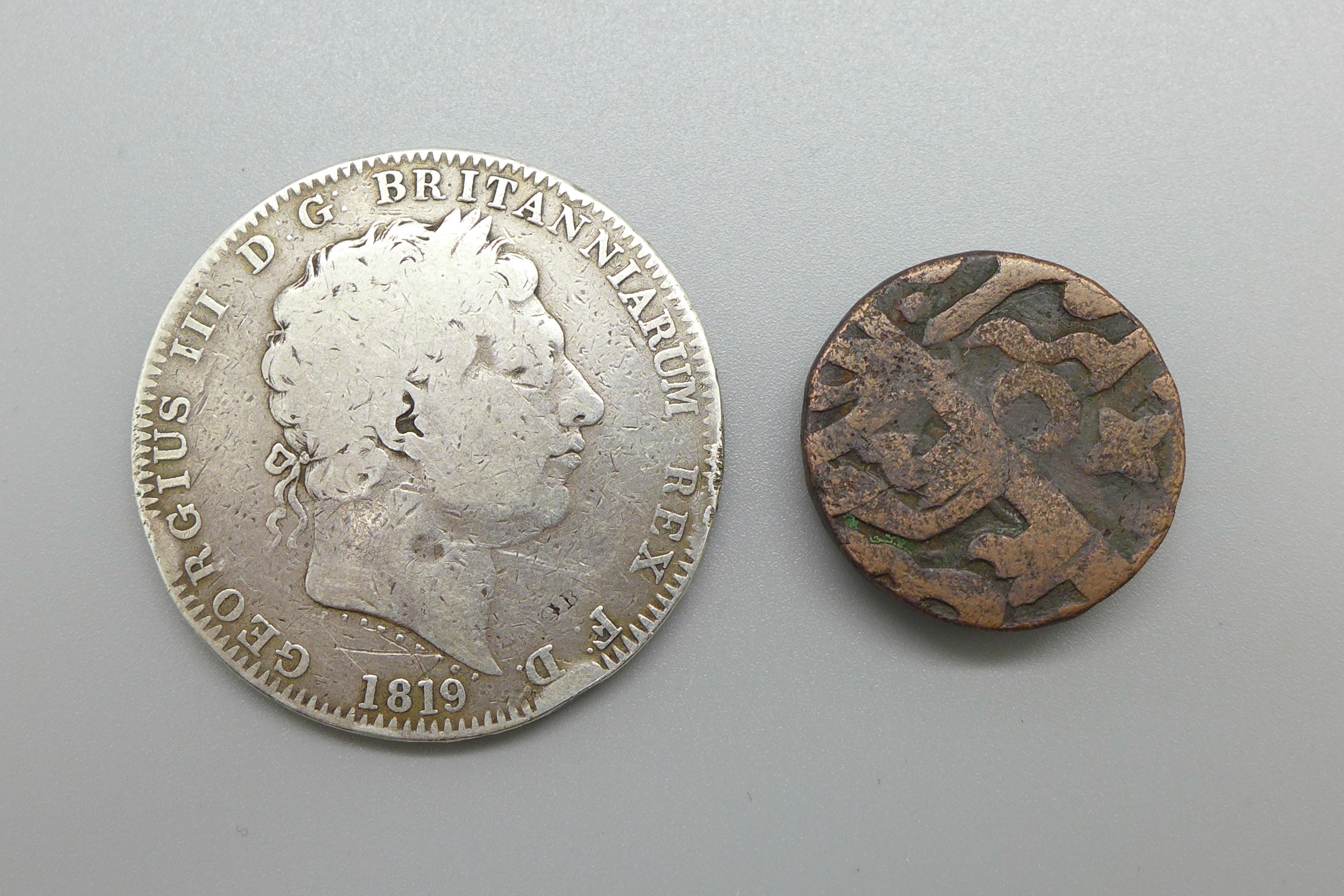 An 1819 George III silver crown and a foreign bronze coin