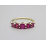 A silver gilt, five stone ruby ring also set with two small diamonds, Q