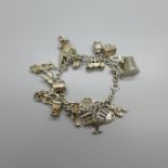 A silver and white metal charm bracelet, 64g