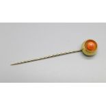 A coral set stick pin, tests as 15ct gold