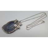 A silver mounted gemstone pendant on a silver chain