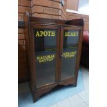 A small oak two door cabinet bearing later painted Apothecary inscription
