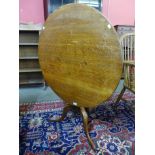 A George III oak circular tilt top tea table