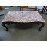 An Italian Rococo style carved wood and rouge marble topped serpentine coffee table