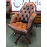 A mahogany and red buttoned leather revolving desk chair