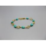 A yellow metal and turquoise bracelet