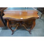 A Victorian mahogany fold over serpentine card table