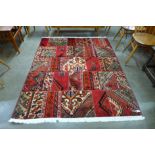 A Persian hand knotted wool patchwork red ground rug
