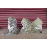 A pair of concrete garden figures of lions capturing rams