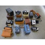 A collection of old cameras, box brownie, folding, Kodak Duaflex II, doll, etc.