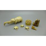 A collection of ivory including a carved pot, an elephant, smaller elephants and a carved figure,