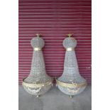 A pair of large French Empire style gilt metal and glass chandeliers